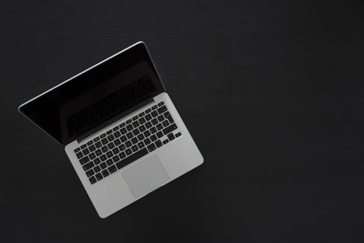 Laptop op een donker bureau, van bovenaf gezien